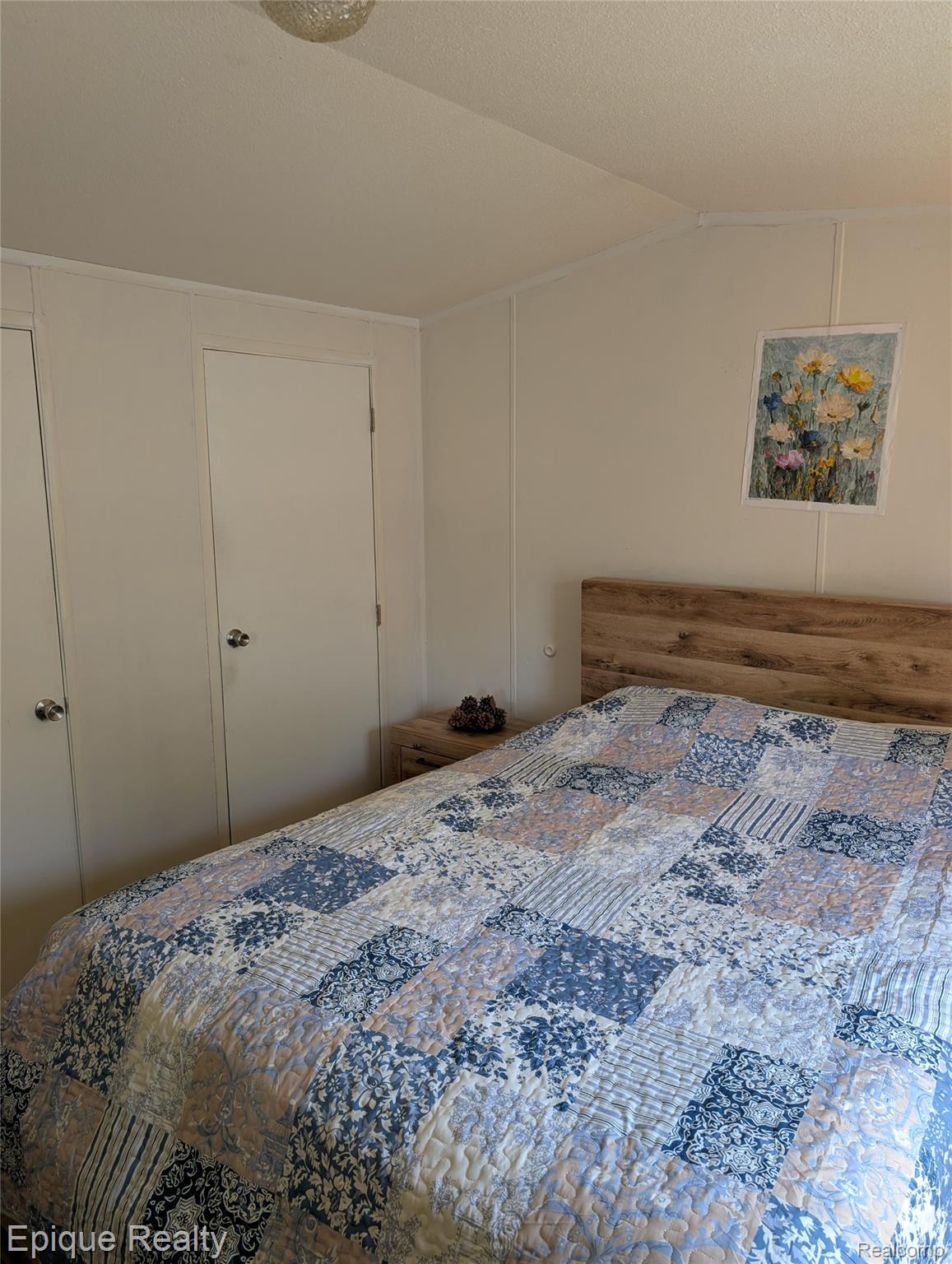 952 Cour Retta Street Warren, MI 48091 - Photo 11 of 19 Bedroom featuring light-toned paneling walls, a wood-finish headboard, built-in wardrobe with white doors, and a ceiling-mounted light fixture