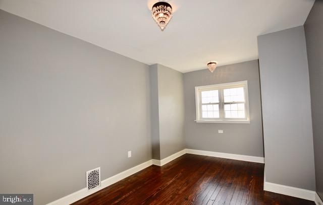 an empty room with a window and wooden floor