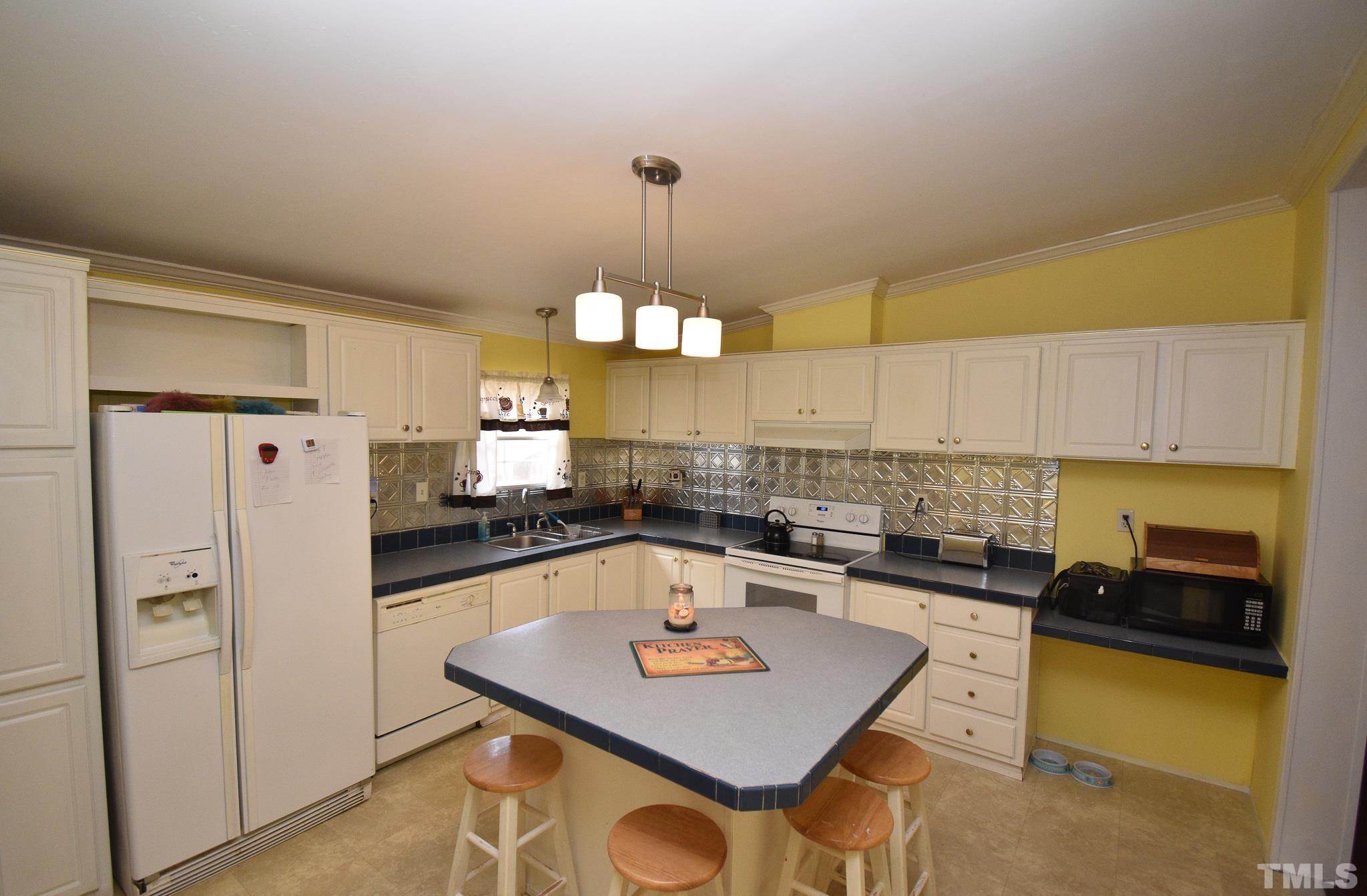 8484 South Creek Road Willow Spring, NC 27592 - Photo 11 of 33 a kitchen with refrigerator and cabinets