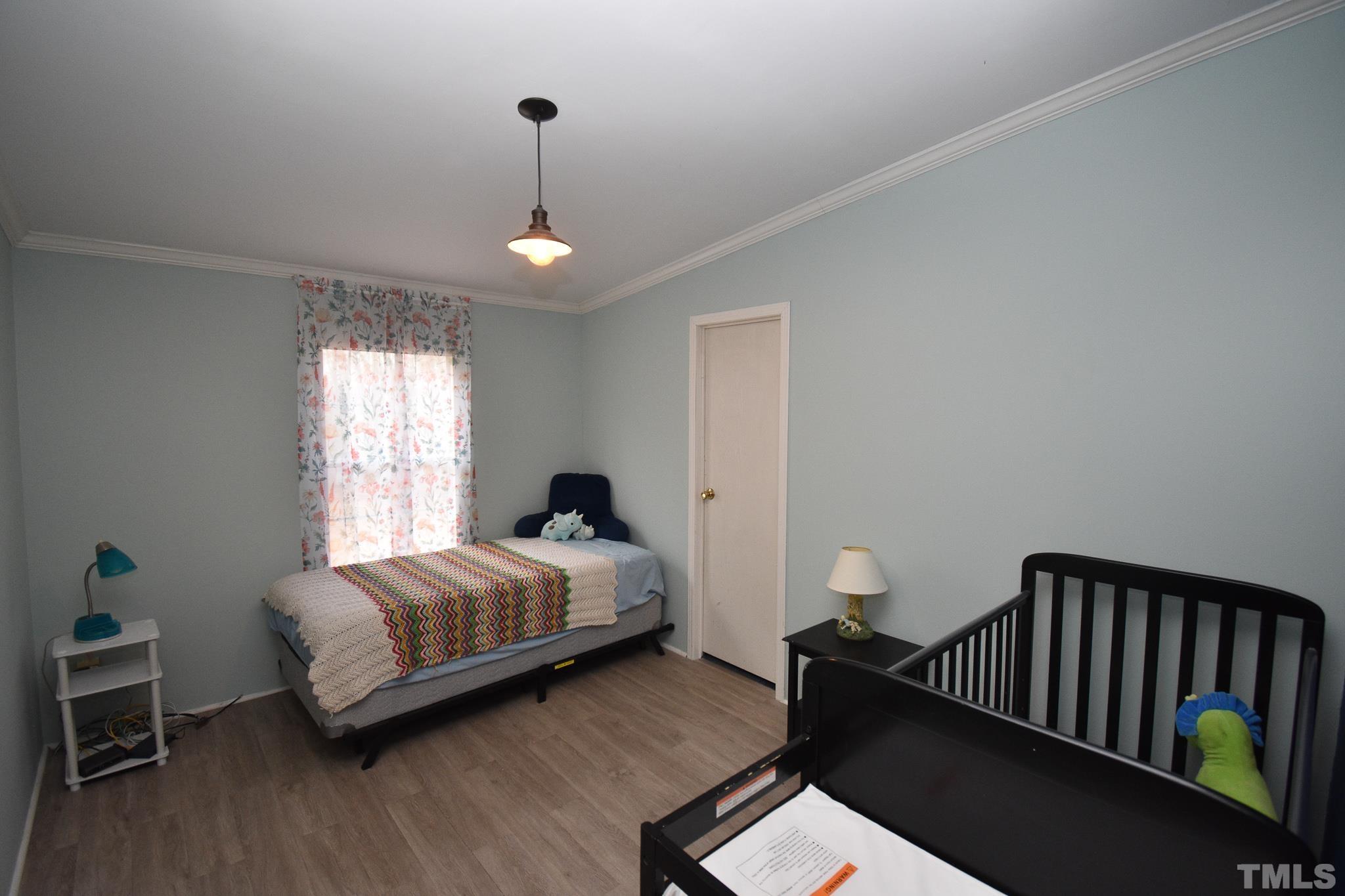 8484 South Creek Road Willow Spring, NC 27592 - Photo 16 of 33 a spacious bedroom with a bed and a window