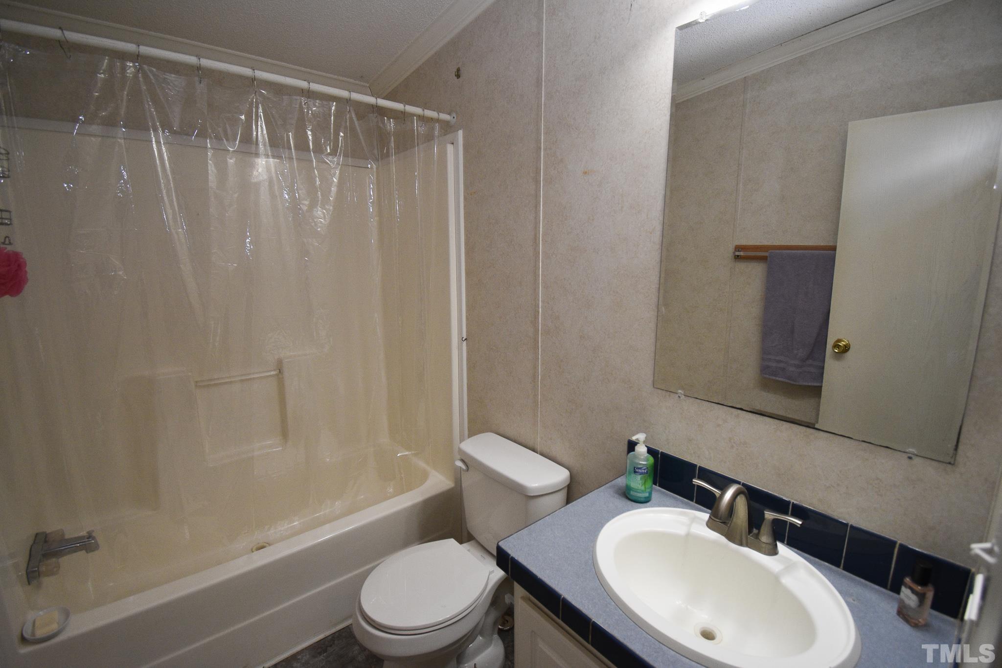 8484 South Creek Road Willow Spring, NC 27592 - Photo 18 of 33 a bathroom with a sink toilet and shower