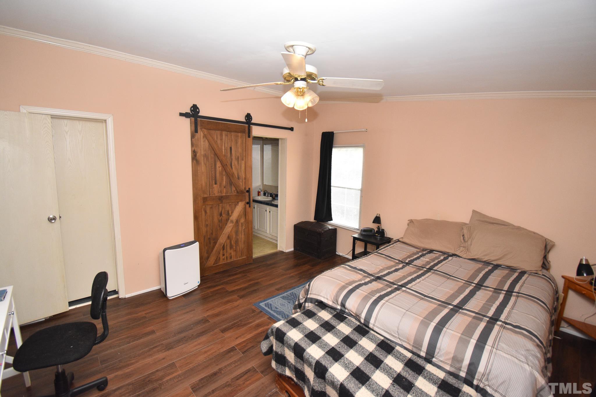 8484 South Creek Road Willow Spring, NC 27592 - Photo 22 of 33 a bedroom with a bed and a chandelier