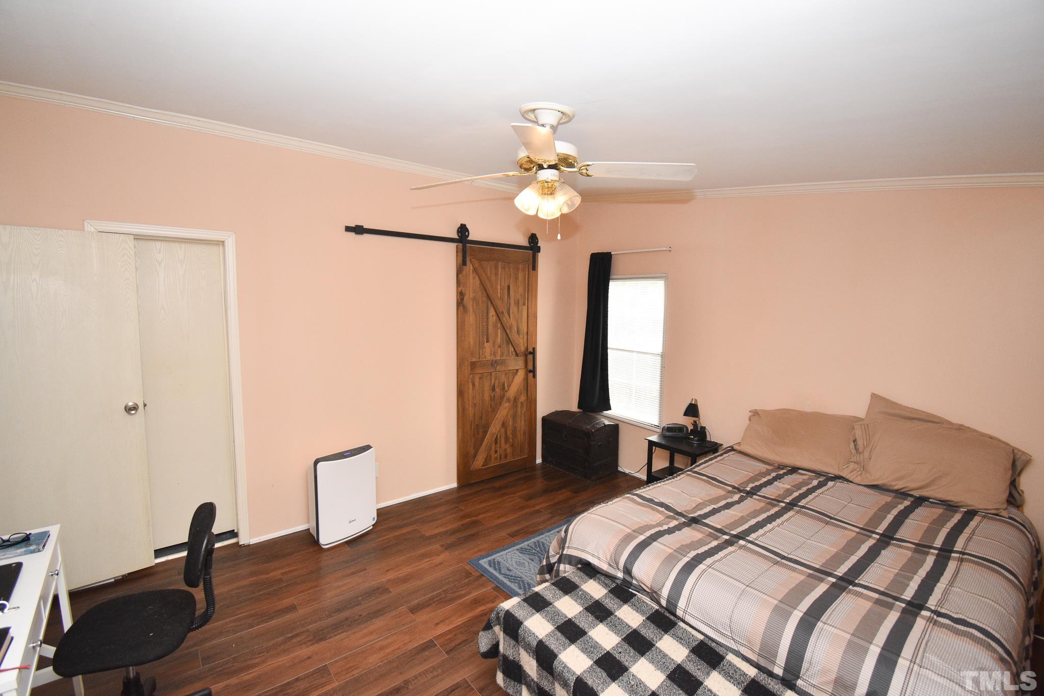 8484 South Creek Road Willow Spring, NC 27592 - Photo 23 of 33 a bedroom with a bed and a chandelier