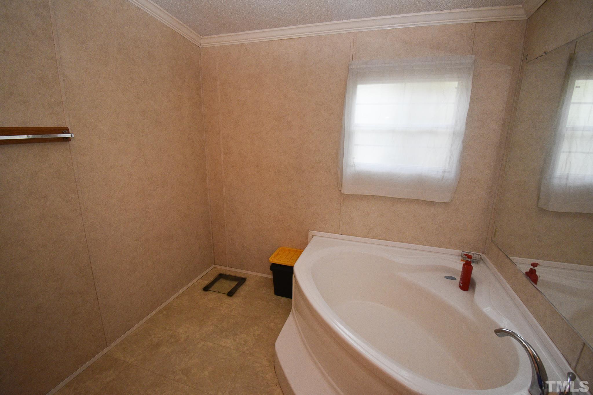 8484 South Creek Road Willow Spring, NC 27592 - Photo 25 of 33 a white bath tub sitting next to a white sink and vanity