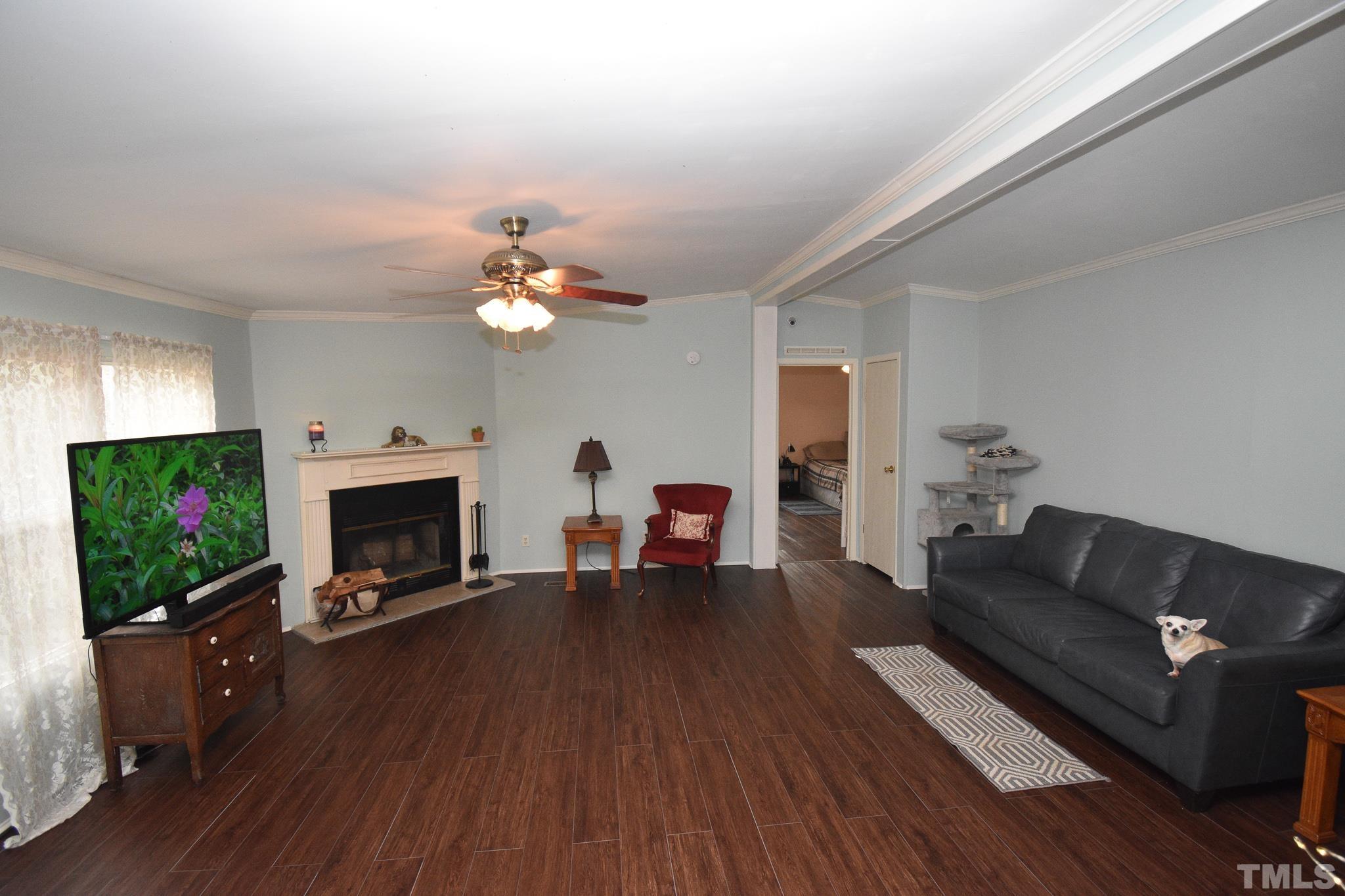 8484 South Creek Road Willow Spring, NC 27592 - Photo 4 of 33 a living room with furniture a flat screen tv and a fireplace