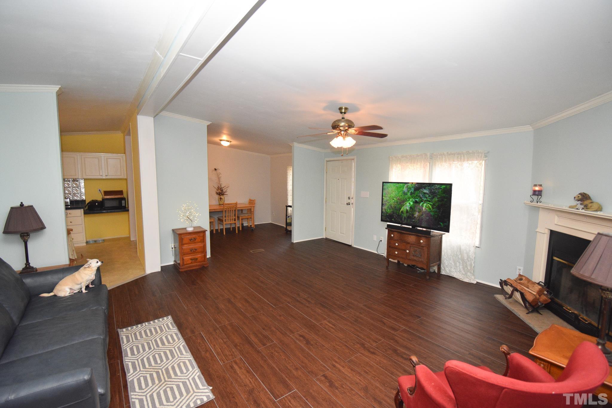 8484 South Creek Road Willow Spring, NC 27592 - Photo 6 of 33 a living room with furniture a flat screen tv and a fireplace