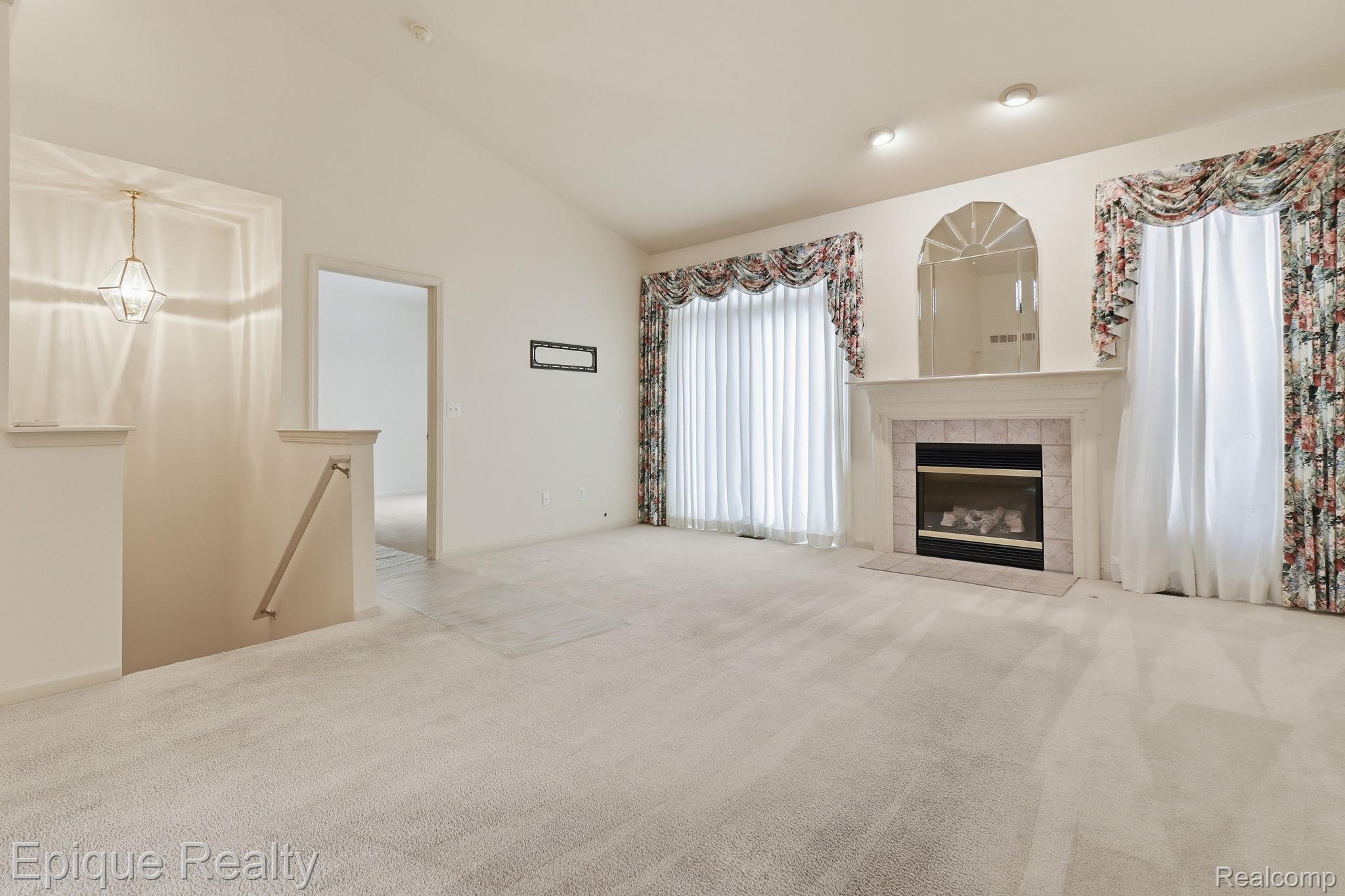 321 Cherry Grove Road Canton, MI 48188 - Photo 3 of 22 Unfurnished living room with carpet flooring, vaulted ceiling, and a tile fireplace
