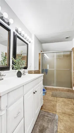 a bathroom with a double vanity sink mirror and shower