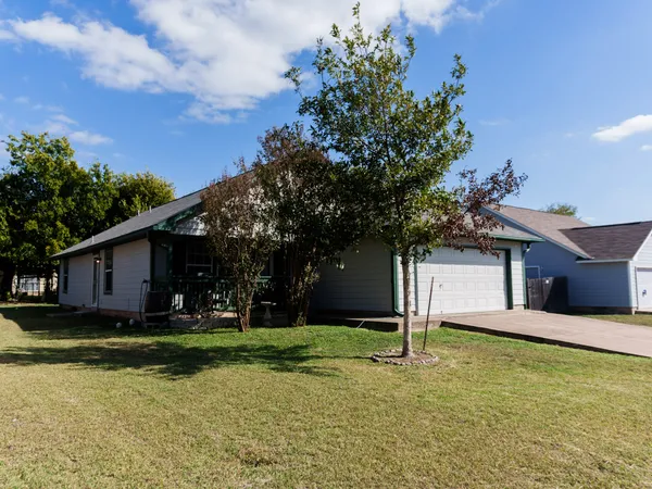 a front view of house with yard and trees