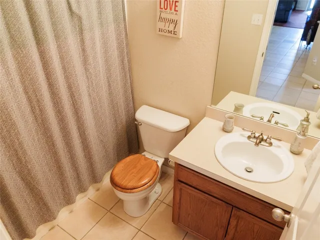 a bathroom with a sink a toilet and shower curtain