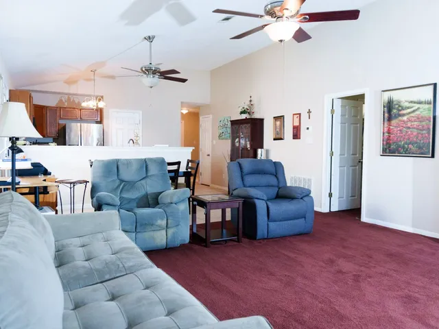 a living room with furniture and a ceiling fan