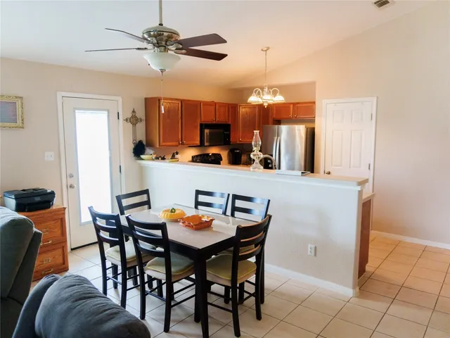 a view of a dining room with furniture and a chandelier fan