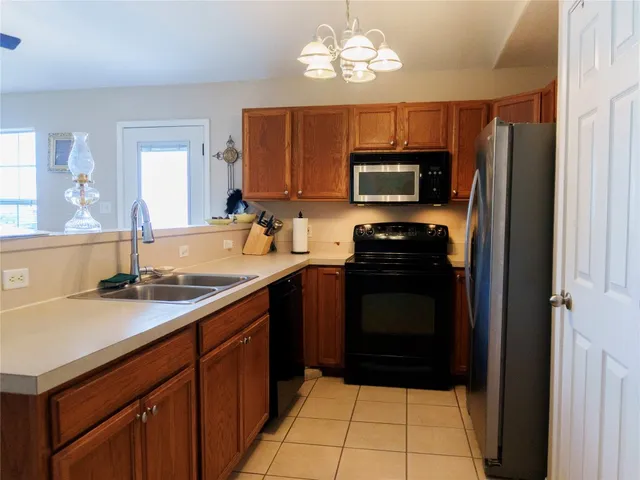 a kitchen with a sink a stove top oven and wooden cabinets