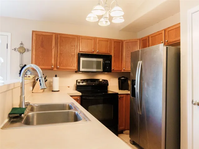 a kitchen with granite countertop a refrigerator and a sink