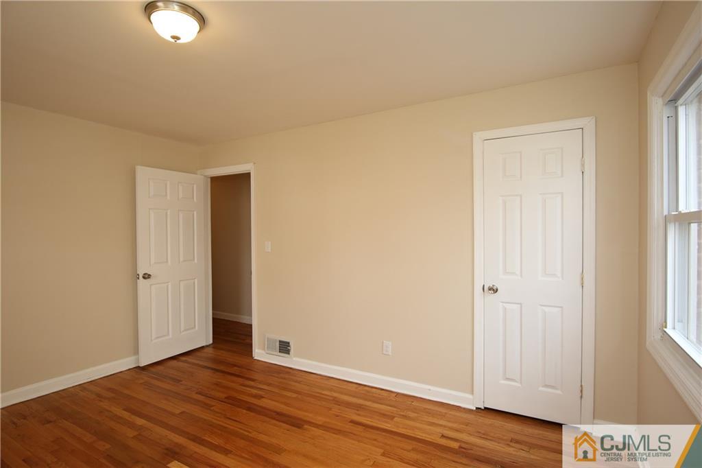 10 Gurley Road Edison, NJ 08817 - Photo 11 of 17 an empty room with wooden floor and windows