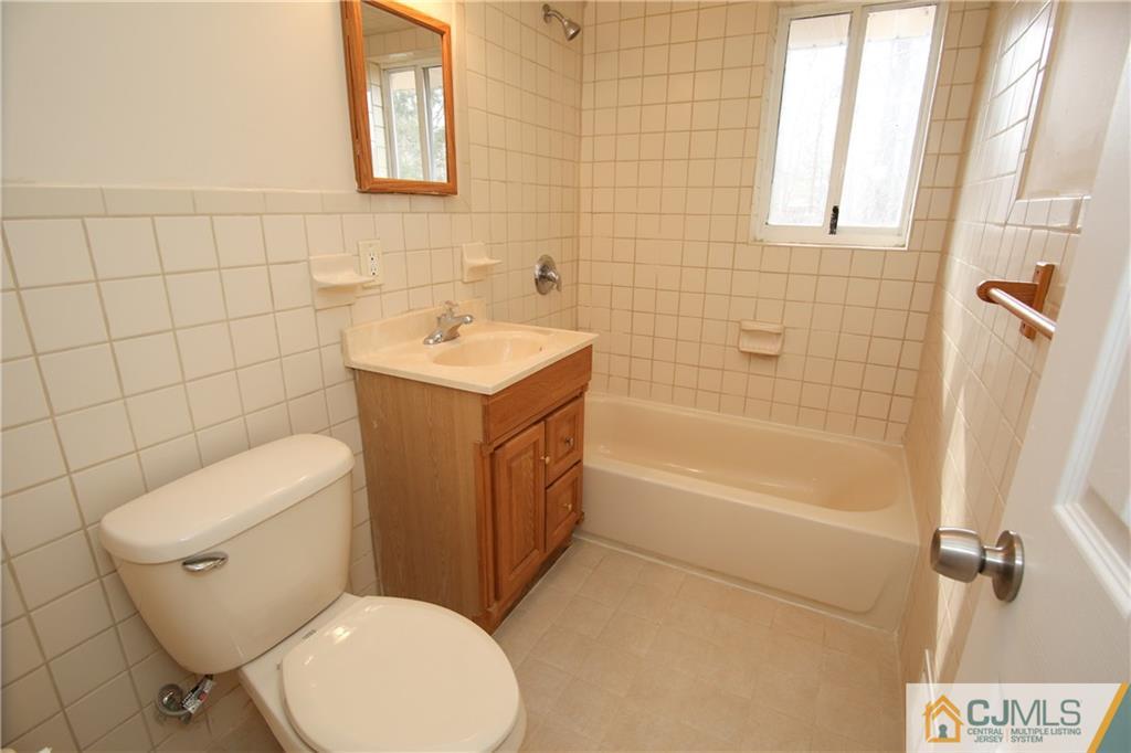 10 Gurley Road Edison, NJ 08817 - Photo 14 of 17 a white toilet sitting next to a bath tub