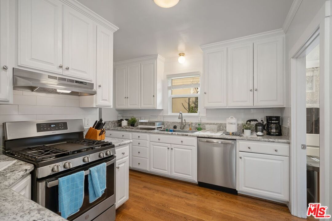 1266 Wesley Avenue Pasadena, CA 91104 - Photo 11 of 25 a kitchen with granite countertop cabinets and stainless steel appliances