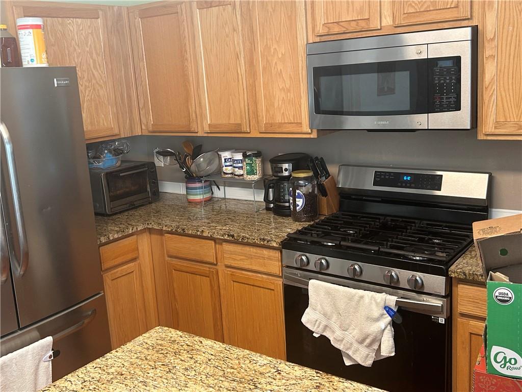 769 Roxholly Lane Northeast Buford, GA 30518 - Photo 29 of 81 a kitchen with stainless steel appliances granite countertop a stove and a microwave