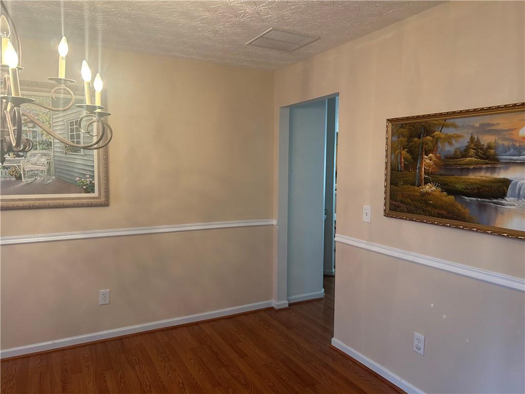 769 Roxholly Lane Northeast Buford, GA 30518 - Photo 41 of 81 a view of a hallway with wooden floor and a bathroom
