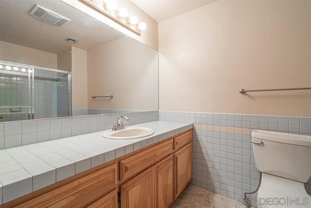 1307 Van Vechten Road El Cajon, CA 92019 - Photo 19 of 24 a bathroom with a sink a toilet and large mirror
