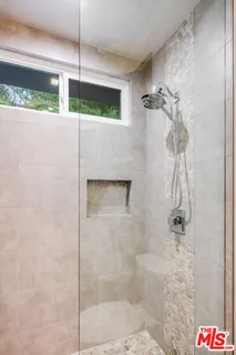 a spacious bedroom with a large bed and a flat tv screen