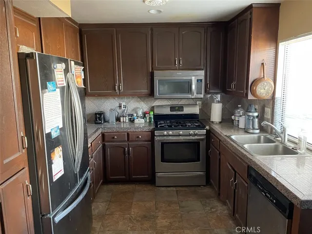 a kitchen with stainless steel appliances granite countertop a refrigerator stove and sink