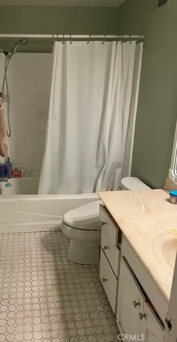 a bathroom with a granite countertop sink and a toilet