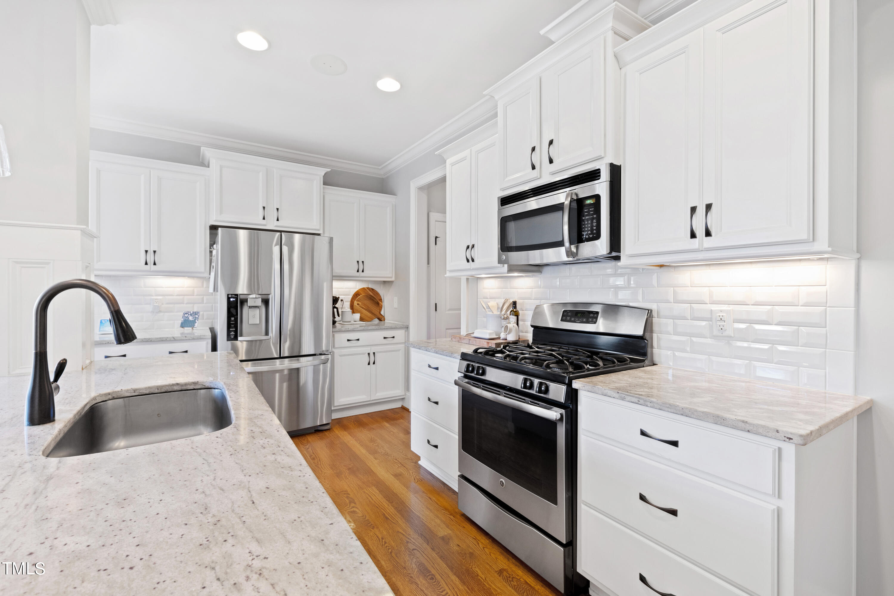6213 Blanche Drive Raleigh, NC 27607 - Photo 11 of 48 a kitchen with stainless steel appliances granite countertop a stove a sink dishwasher a refrigerator and a stove with wooden floor