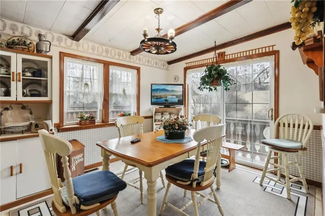 a view of a dining room with furniture a chandelier and wooden floor