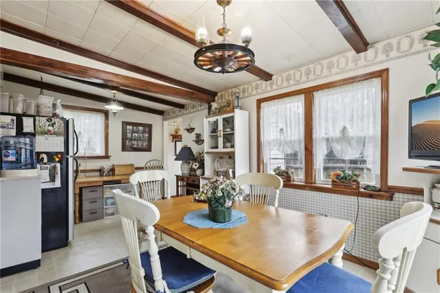 a view of a dining room with furniture a chandelier and large windows
