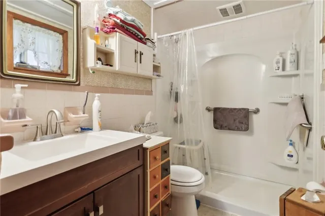 a bathroom with a sink mirror vanity and toilet
