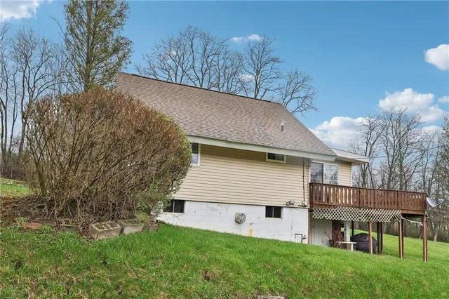 a aerial view of a house next to a big yard and large trees