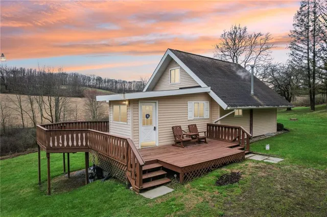 a view of a house with a yard and deck