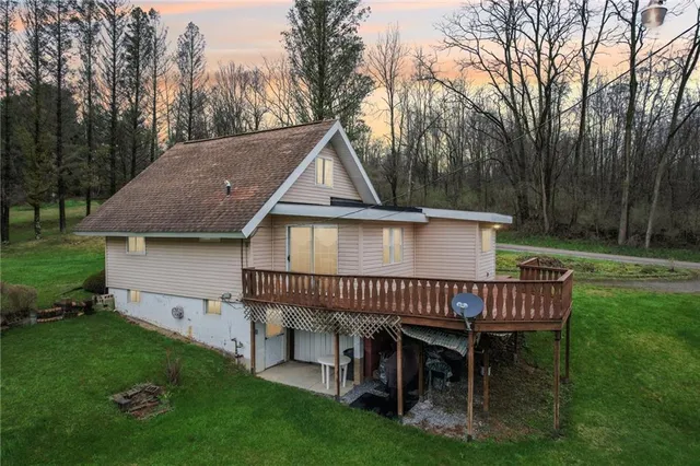 a view of a house with a deck and a yard