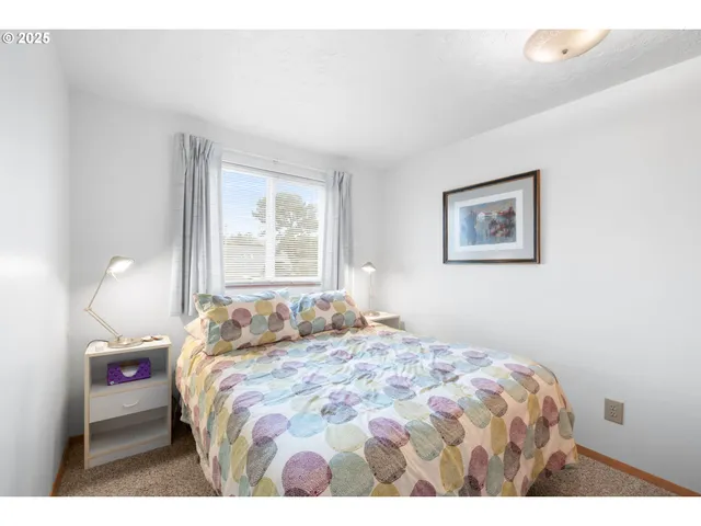 a bedroom with a bed and painting on the wall