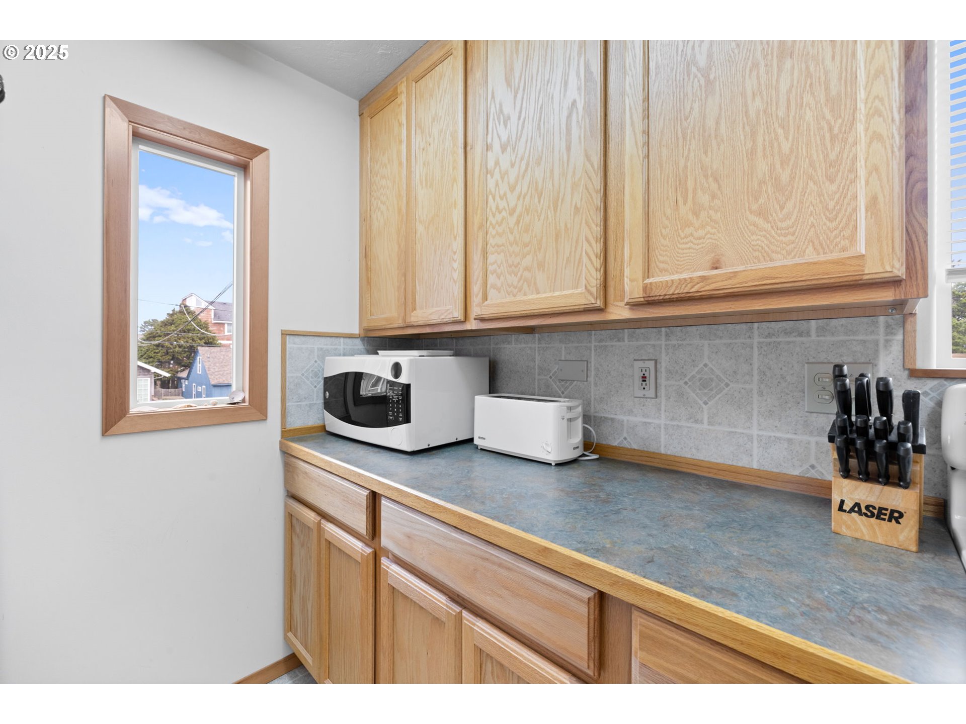 337 16th Avenue Seaside, OR 97138 - Photo 14 of 38 a kitchen with stainless steel appliances granite countertop a sink and a white cabinets