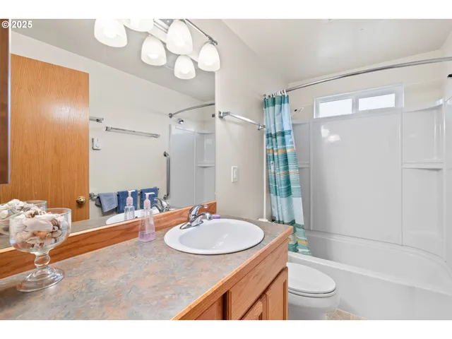 a bathroom with a sink a toilet a mirror and shower