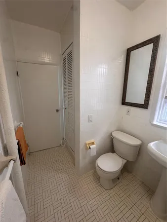 a bathroom with a toilet and a mirror