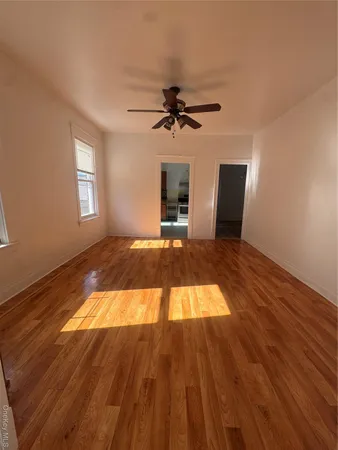 a view of a livingroom with wooden floor and a ceiling fan