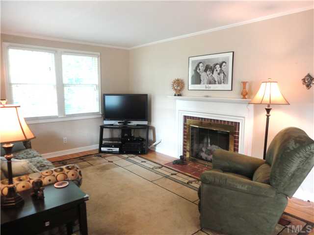 1206 Clifton Street Raleigh, NC 27604 - Photo 4 of 25 a living room with furniture a flat screen tv and a fireplace