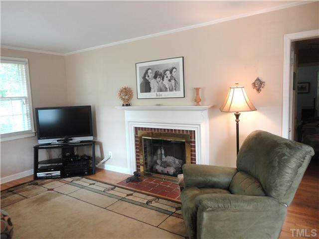 1206 Clifton Street Raleigh, NC 27604 - Photo 7 of 25 a living room with furniture a flat screen tv and a fireplace