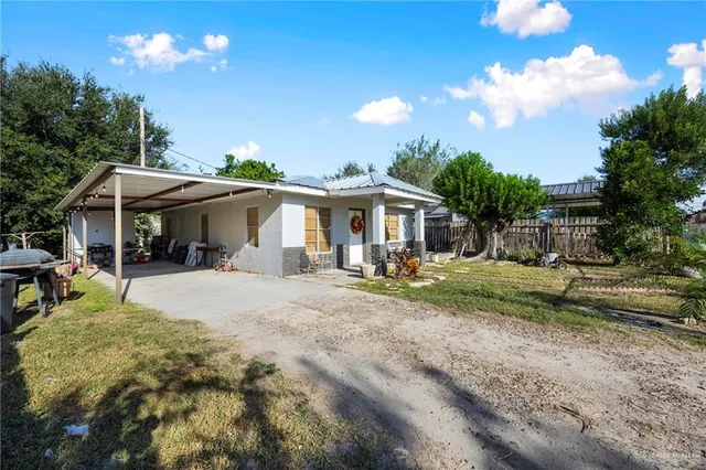 a view of a house with backyard and sitting area