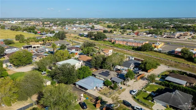 an aerial view of a city with lots of residential buildings ocean and mountain view in back