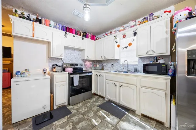 a kitchen with granite countertop a white stove top oven sink and cabinets