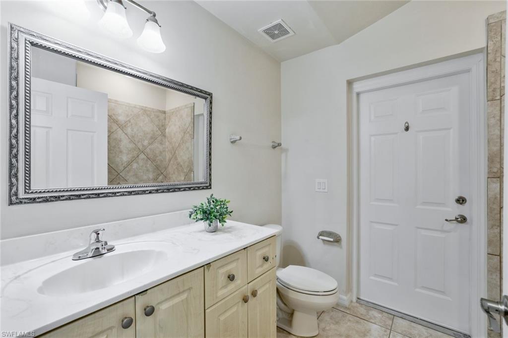 18355 Fuchsia Road Fort Myers, FL 33967 - Photo 11 of 13 a bathroom with a granite countertop sink a toilet and shower