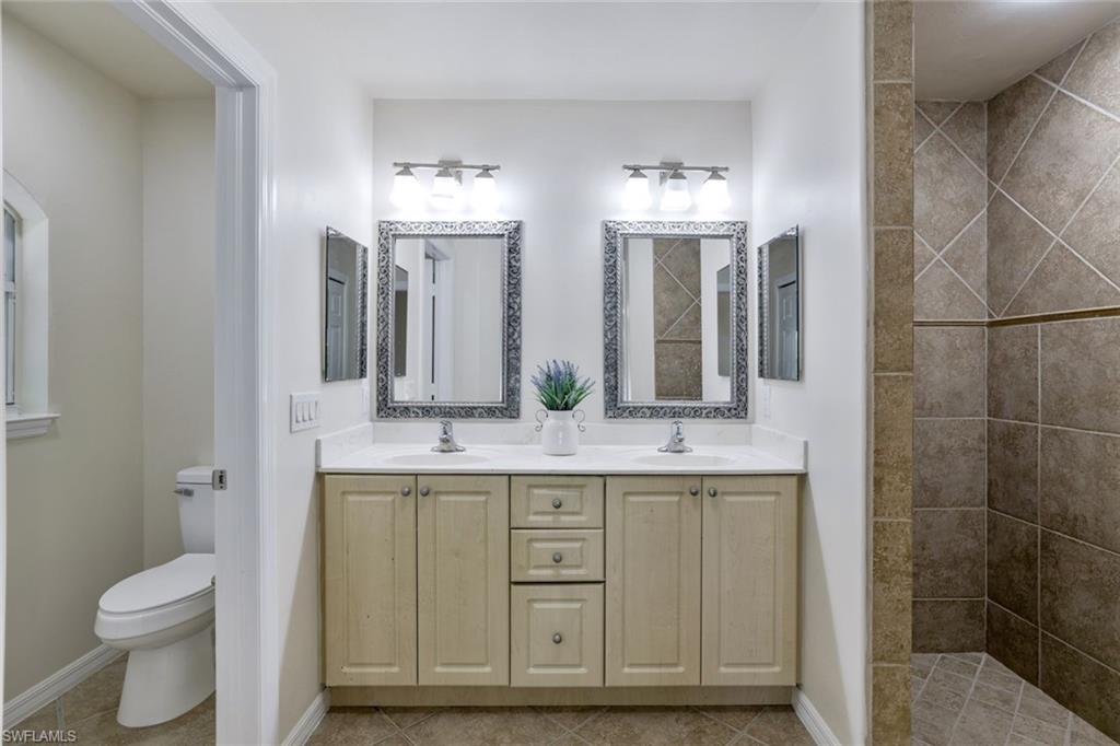 18355 Fuchsia Road Fort Myers, FL 33967 - Photo 6 of 13 a bathroom with a granite countertop sink a toilet and a mirror