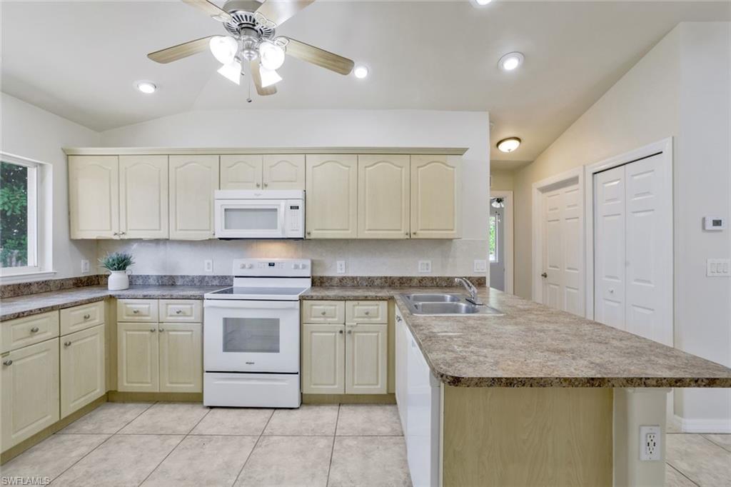 18355 Fuchsia Road Fort Myers, FL 33967 - Photo 9 of 13 a kitchen with a stove sink and cabinets