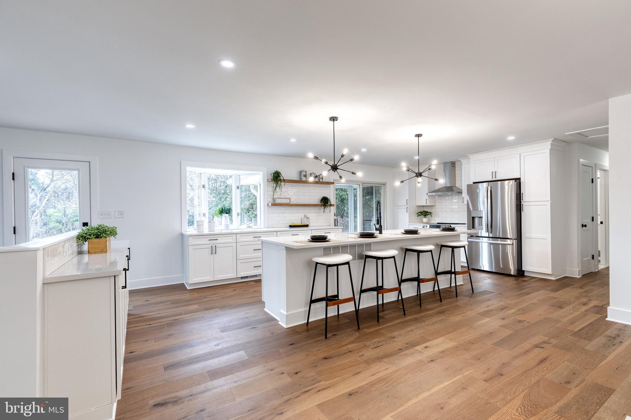 4011 Perry Hall Road Perry Hall, MD 21128 - Photo 26 of 51 a kitchen with stainless steel appliances kitchen island granite countertop a refrigerator a stove a dining table and chairs with wooden floor