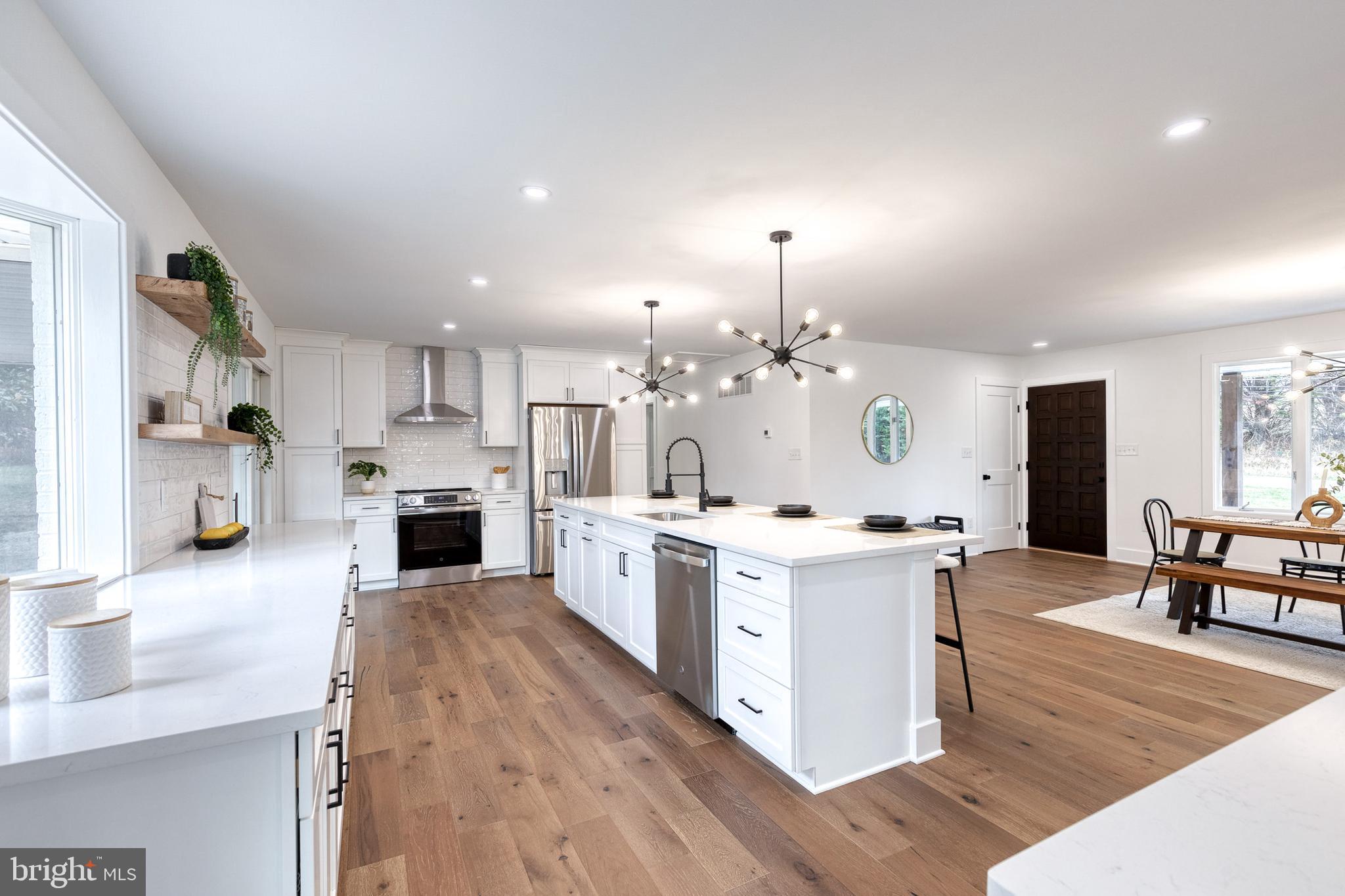 4011 Perry Hall Road Perry Hall, MD 21128 - Photo 28 of 51 a large kitchen with kitchen island a island a stove a sink dishwasher a oven and a dining table with wooden floor
