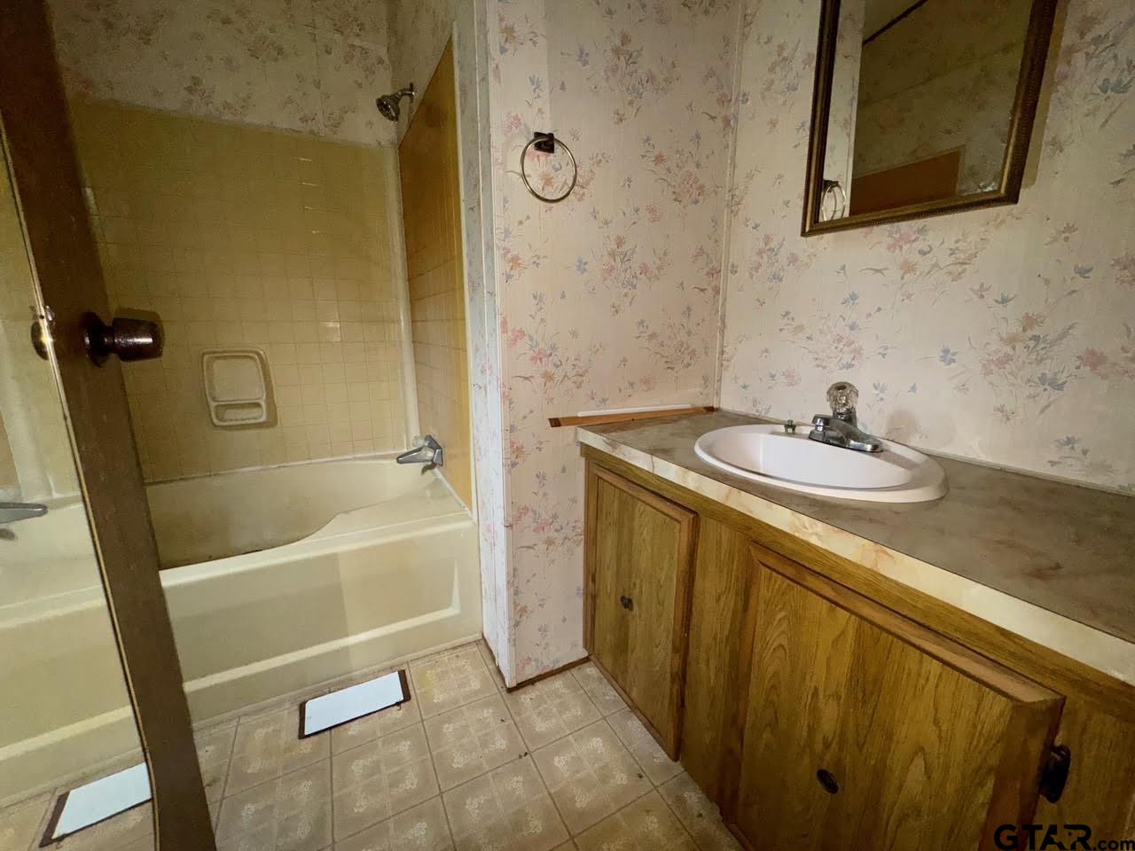 8505 Park Lane Tyler, TX 75708 - Photo 8 of 18 a bathroom with a sink a mirror and a bathtub